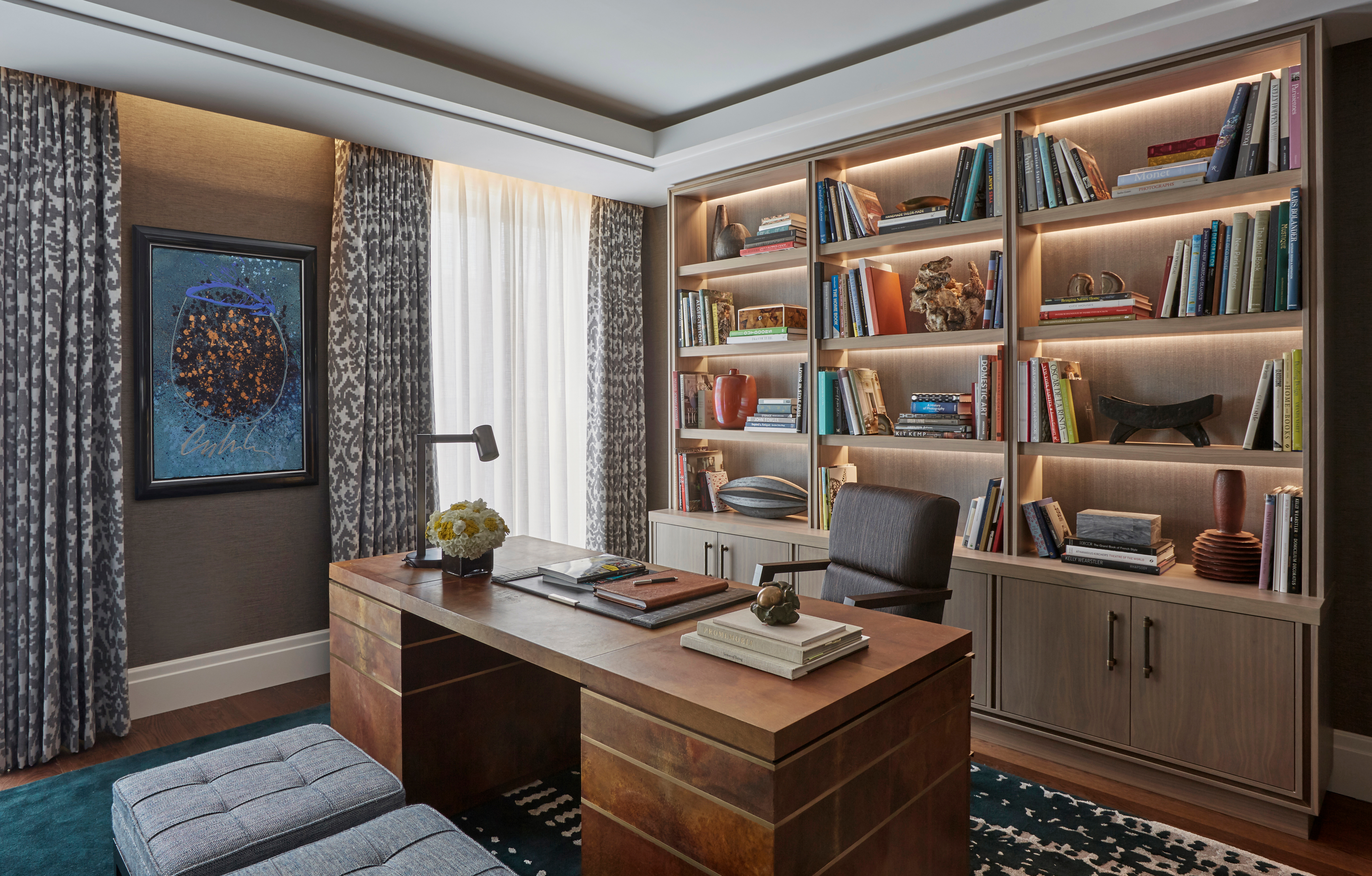 Luxury home office with bespoke desk and armchair with joinery unit